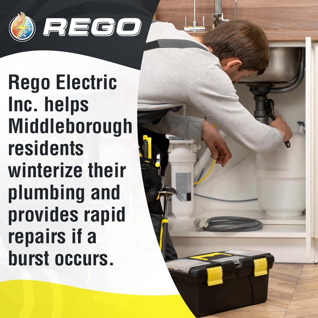 Plumber repairing pipes under kitchen sink to prevent winter burst pipe damage.