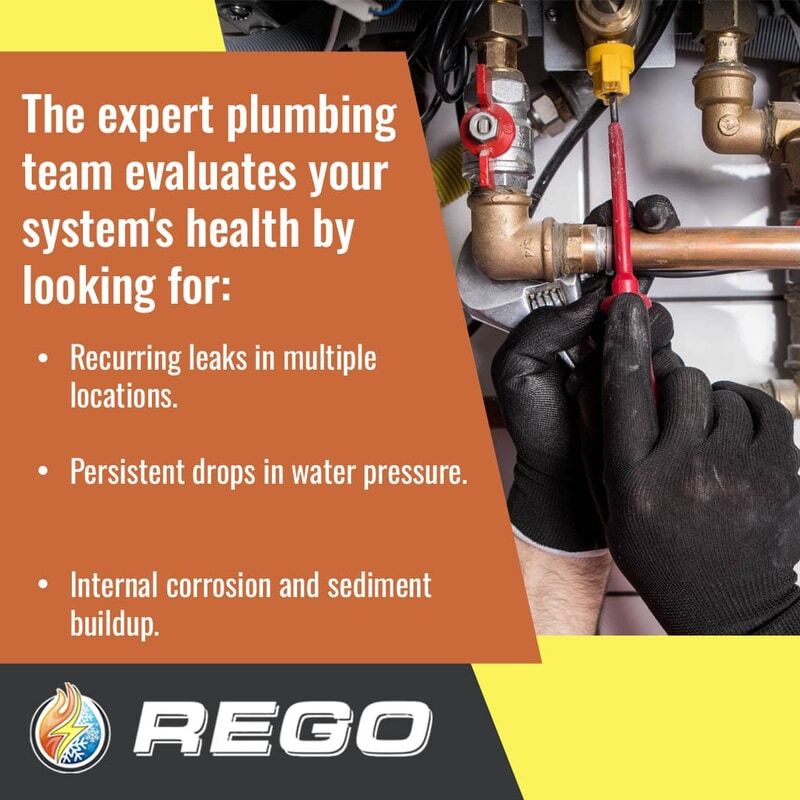 A close-up view of a plumber in black work gloves using a tool on residential copper piping and valves to check for leaks, corrosion, and water pressure issues. Image 3